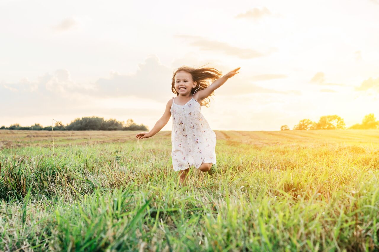 A girl playing in a field of grass